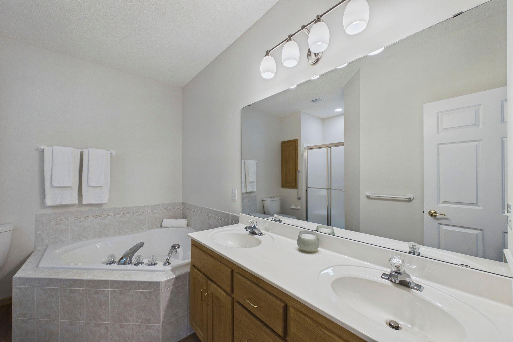 Private primary bath featuring a double vanity, soaking tub and separate walk-in shower