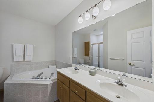 Private primary bath featuring a double vanity, soaking tub and separate walk-in shower