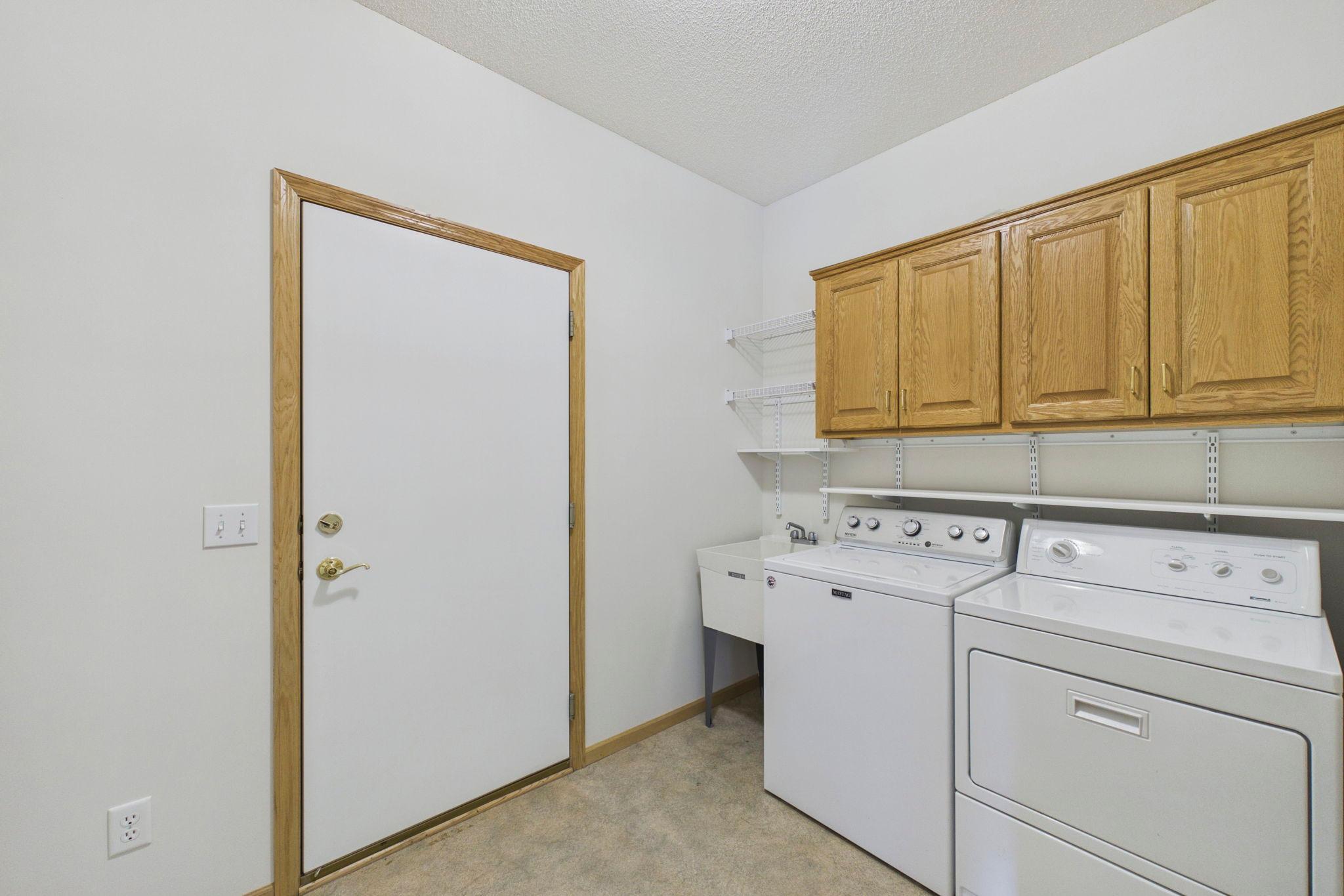 Main-floor laundry with built-in storage, shelving and utility sink adds everyday convenience to one-level living.