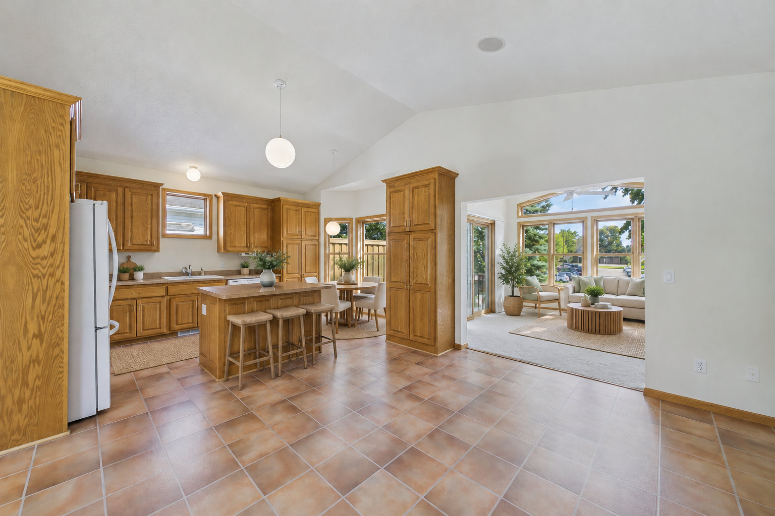Virtually staged to showcase the open flow from the kitchen and dining area into the light-filled sunroom.