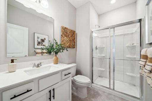 Main level bedroom and 3/4 bath. Perfect for guests or main level living. Photo is of previously built model home, finishes, selections, and colors may vary.