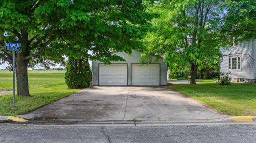 Detached 2-stall garage with concrete driveway and concrete walkway to the house