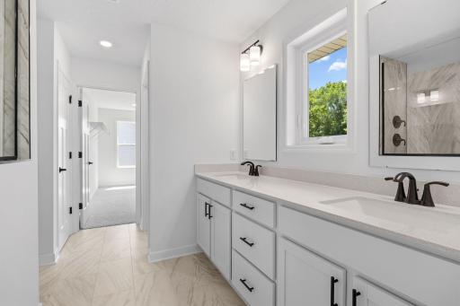 Dual rectangular undermount sinks and chrome fixtures sit atop the stylish vanity to complement busy lifestyles