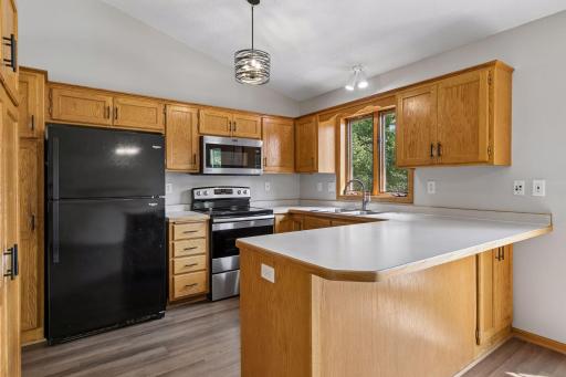 Kitchen offers a breakfast bar, stainless appliances and brand new light fixture and hardware pulls.