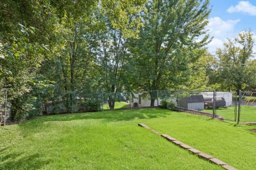 Fenced part of the backyard with a perimeter of trees.