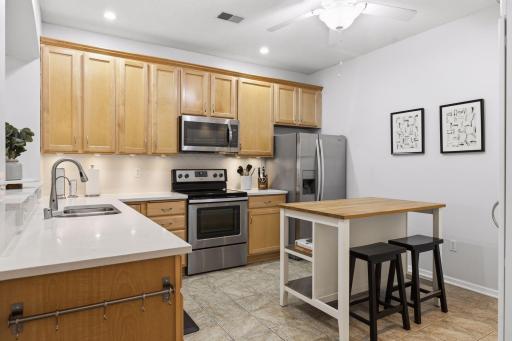 Stylish Quartz Counters Paired with a Functional Butcher Block Island