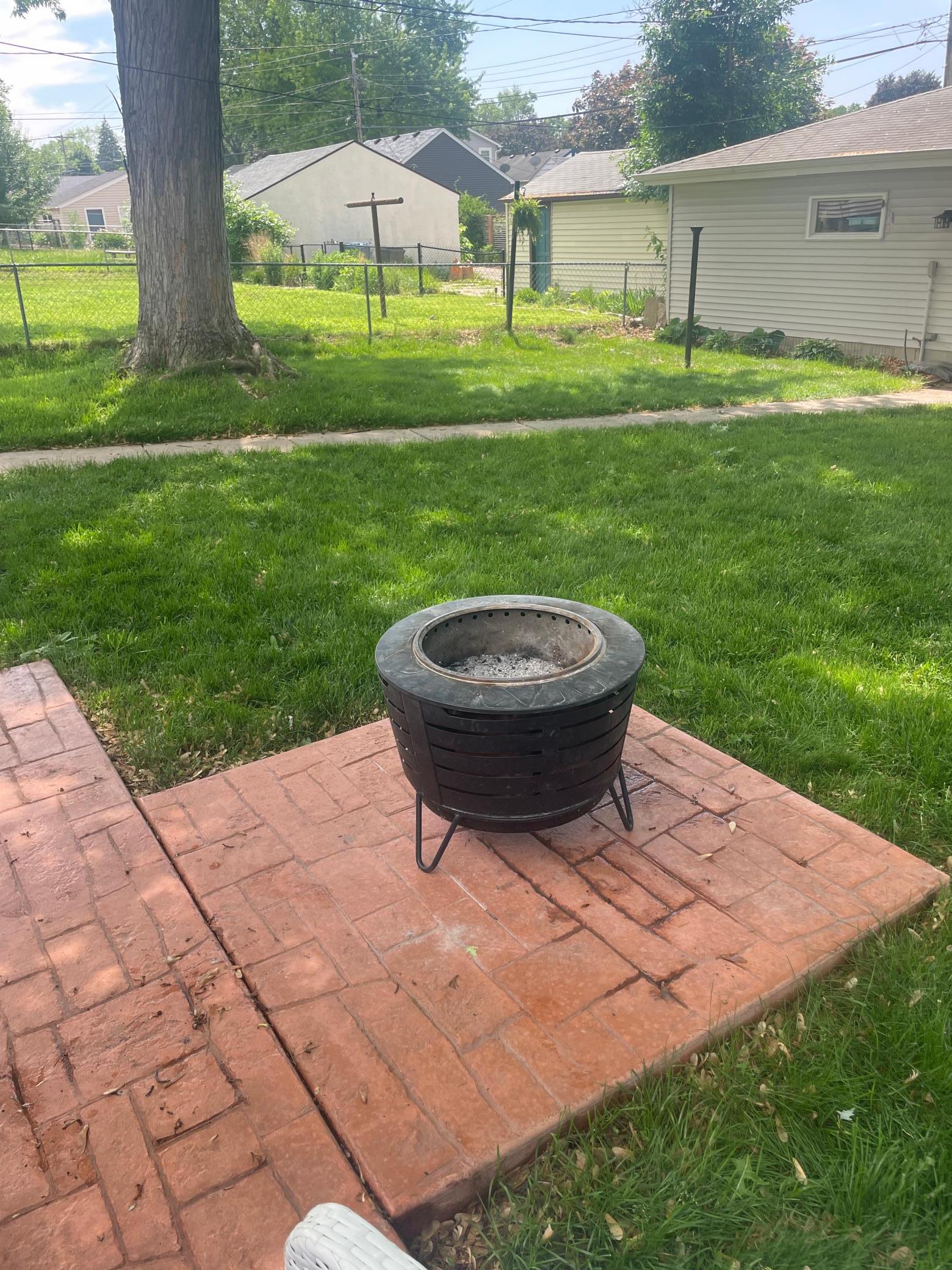 Gorgeous stamped concrete patio with a place for a grill or firepit. (It had just rained so it is a bit wet)