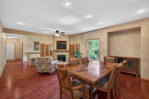 Rich hardwood flooring, custom built-in cabinetry, and a cozy fireplace create a warm and inviting atmosphere perfect for both everyday living and entertaining.