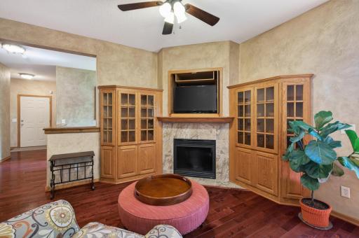 Gather around the warm and inviting fireplace that serves as the focal point of this beautiful great room. Custom built-in display cabinets & entertainment center with rich hardwood flooring making it ideal for entertaining family and friends.