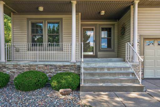 This attractive entryway features maintenance-free exterior finishes, stone accents, and a spacious porch