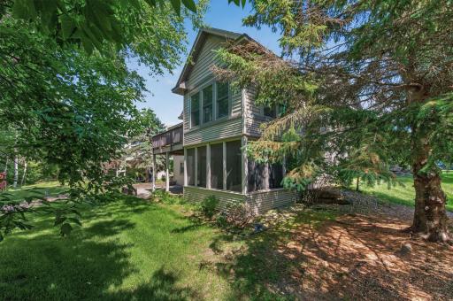 The rear exterior showcases one of this home's most desirable featuresâits exceptional private setting surrounded by mature trees and protected green space.