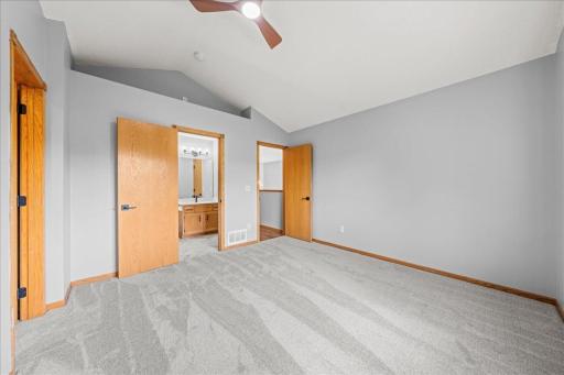 Additional view of primary bedroom with doors leading to walk-in closet (left), bathroom (center) and hallway (right)