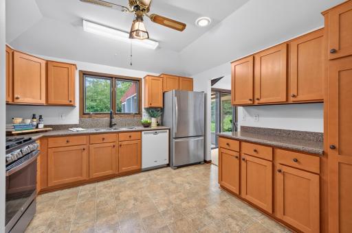Spacious and functional, this inviting kitchen features plenty of room to cook and gather, complemented by a sleek stainless steel refrigerator and gas range. Along with abundant workspace and pantry.