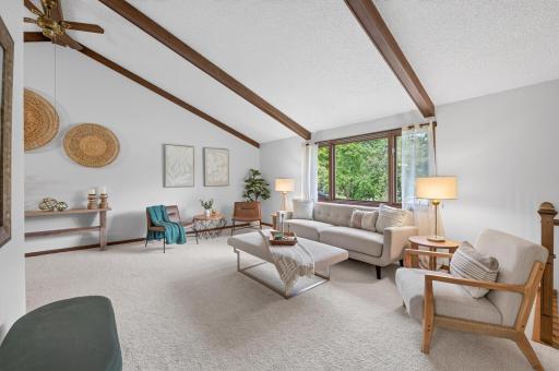 Sun-drenched living room featuring exposed wood beams, warm natural textures, and an inviting open atmosphere.