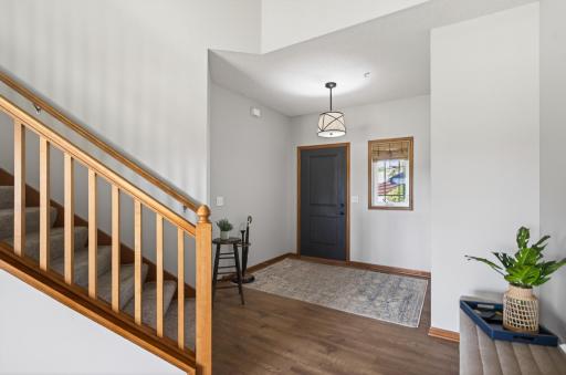 Welcoming two-story foyer with updated lighting and engineered flooring.