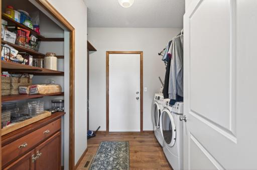 Convenient main-level laundry and mudroom with built-in pantry storage and exterior access.