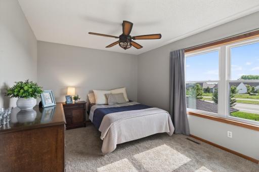 Upper level 3rd bedroom with large window, updated ceiling fan, and neighborhood views.