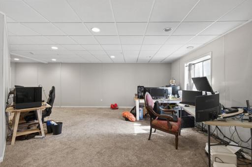 Expansive lower-level flex space with soundproofing and versatile layout options. Currently being used as a home office/ online schooling space.
