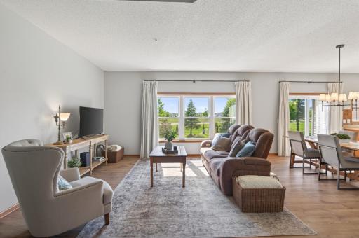 Bright living room with large windows overlooking the backyard.