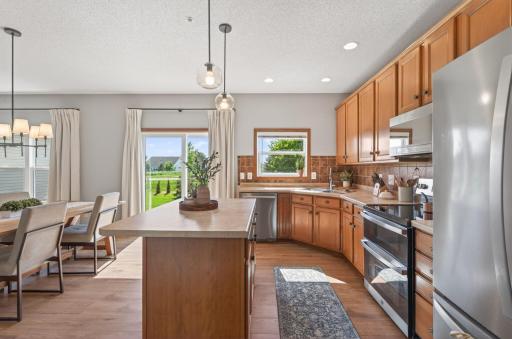 Kitchen featuring stainless steel appliances, tile backsplash, and center island.