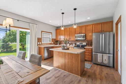 Kitchen with center island, stainless steel appliances, and ample cabinet storage.