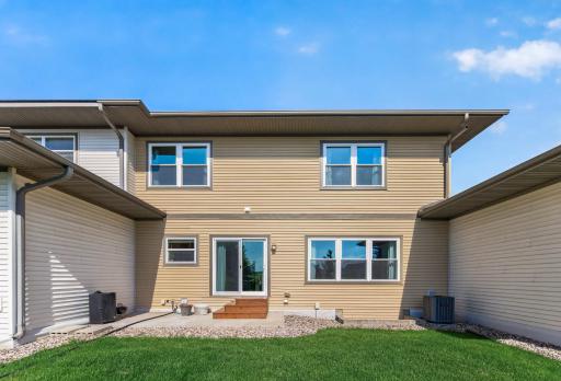 Rear exterior featuring low-maintenance landscaping, patio area, and spacious backyard setting.