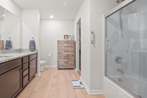 Oversized primary bathroom with new shower door, dual sink vanity and walk-in closet.