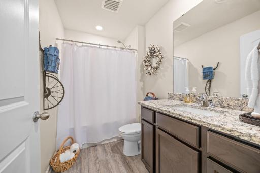 Lower level full bathroom with granite countertops and espresso cabinetry.
