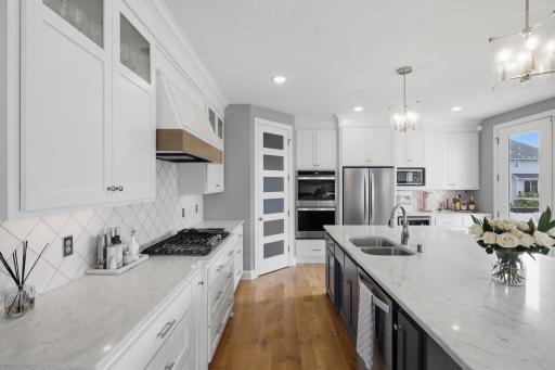 Spacious kitchen with pantry, double ovens, glass upper cabinets. Sleek and clean!