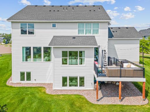 Back exterior features clean landscaping and a grea deck with cozy furniture - excellent for grilling!