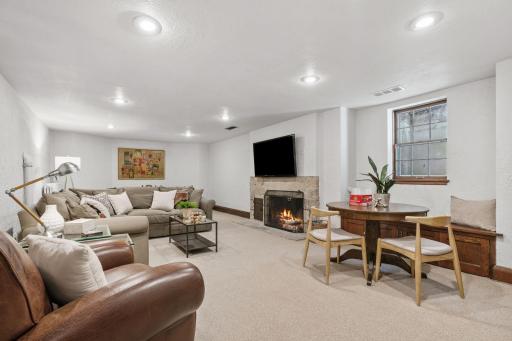 Large family room with recessed lighting and non-operational fireplace with TV