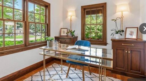 Main floor office with built in cabinetry and floor outlet