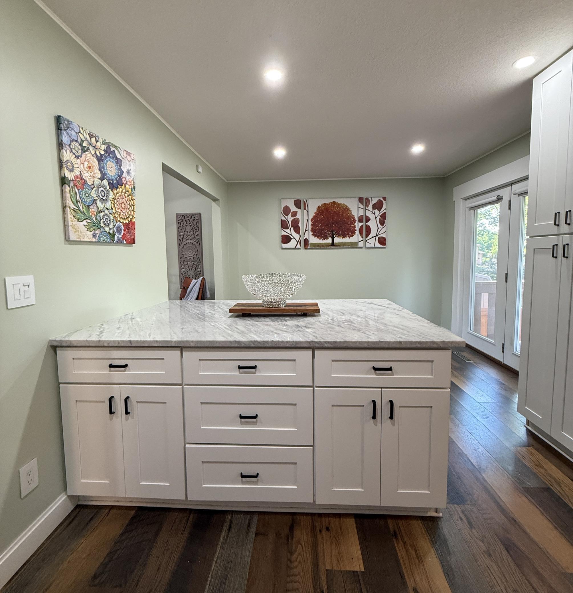 The extra-large kitchen island features storage on both sides, a marble top, and ample space for bar stools, making it ideal for easy entertaining.