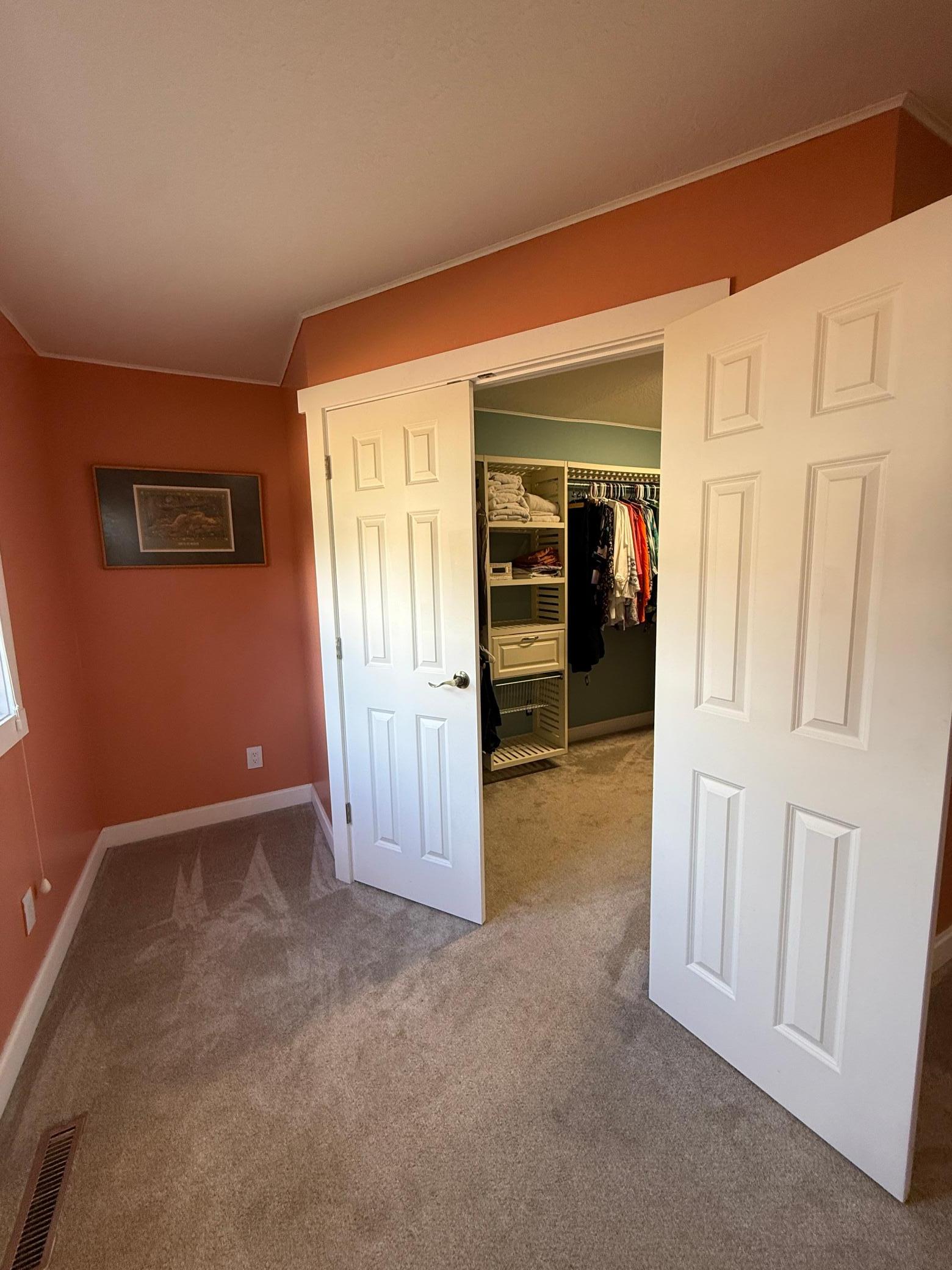 Primary suite walk-in closet with double doors.