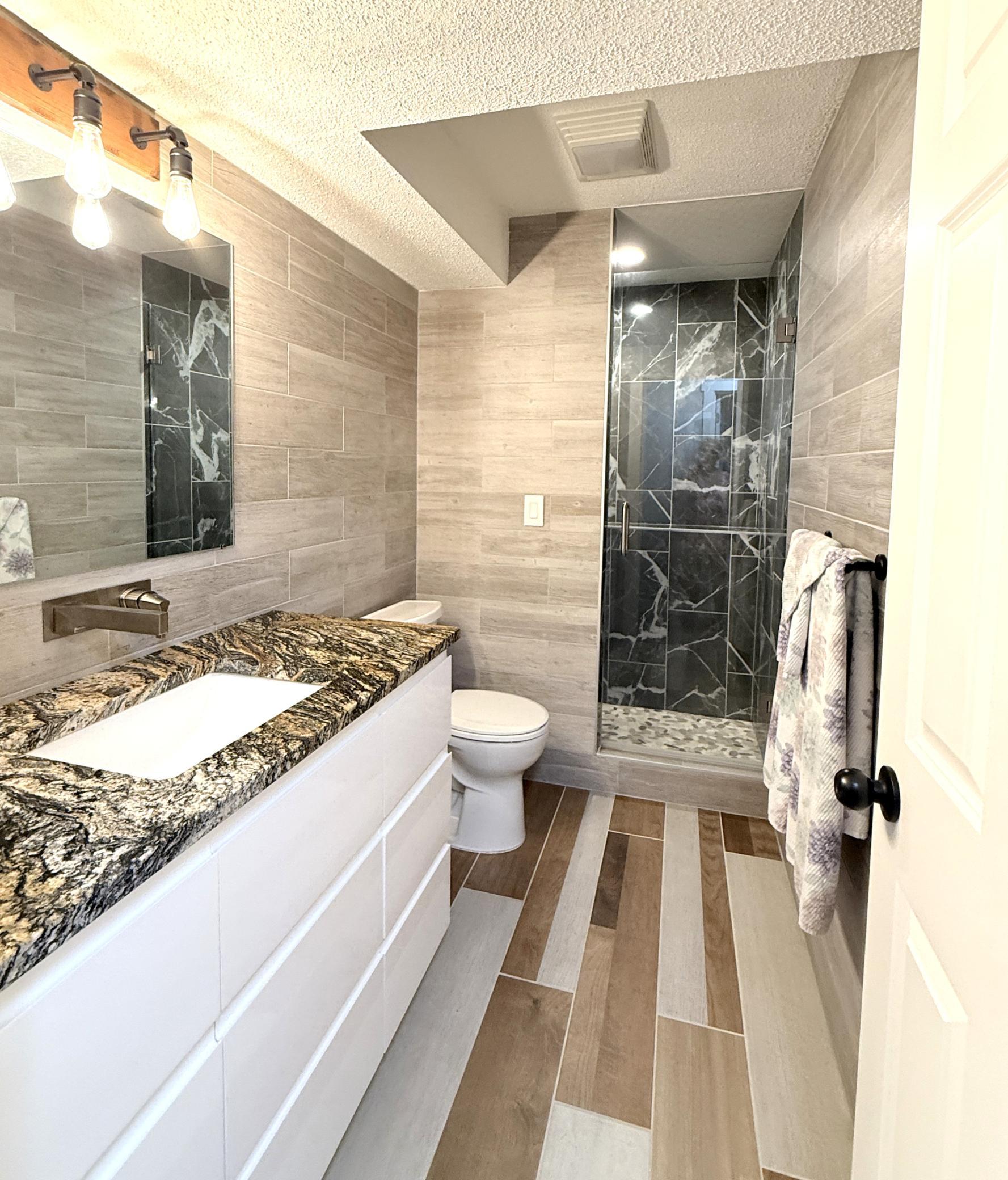 Lower-level tiled bathroom.