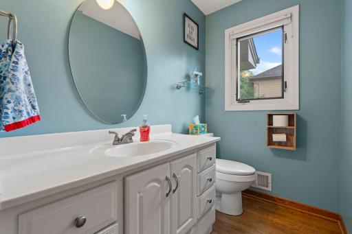 Convenient main level bathroom with hardwood floors and a pop of color.