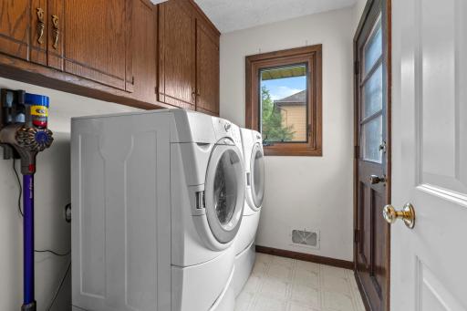 Main level laundry with walkout to deck. Storage cabinetry for extra storage.