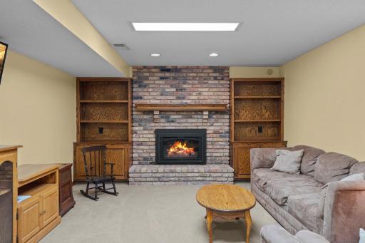Cozy lower-level, family room fireplace with accent built-ins and shelving. New gas insert!