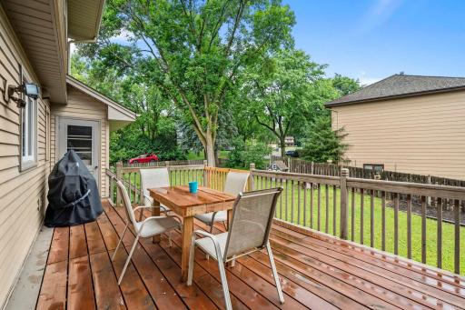 Deck overlooks large, fenced backyard and concrete patio.