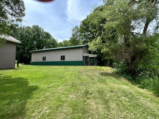 Side shot of accessory building with dog kennel in back.