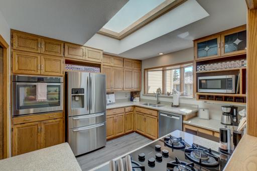 The heart of the home features an updated kitchen with stone countertops, stainless steel appliances, and abundant workspace!