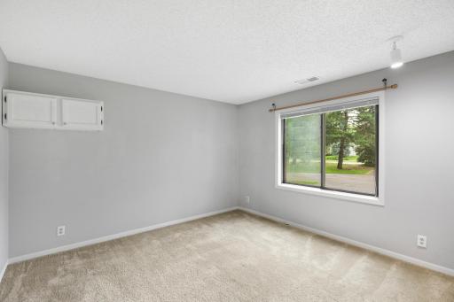 Large primary bedroom with peaceful neighborhood views.