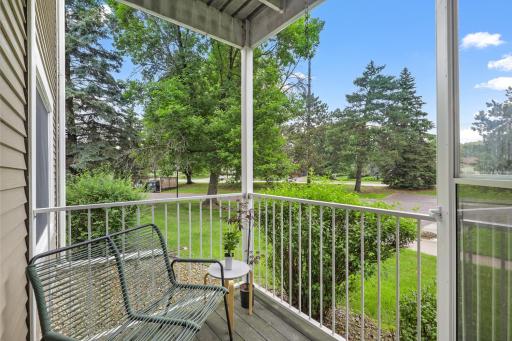 Private balcony overlooking mature trees and green space.