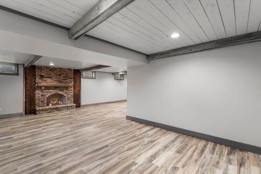 Cozy lower level highlighted by wood paneling and beam ceiling accents