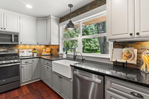 Stunning kitchen built for a chef, complete with farmhouse sink and a large backyard-facing window