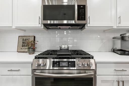 14909 Archdale Lane_A gas range and sleek tile backsplash give this kitchen a professional edge.