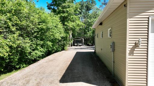 22' wide Class 5 Driveway running alongside outbuilding leading to the back parking area