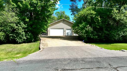 Secondary Driveway access to Outbuilding and additional parking areas features a a crushed limestone drive in front of the garage, with a class 5 parking area behind it.