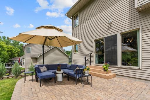 Peaceful backyard w/ oversized paver patio, mature trees, privacy + extensive landscaping