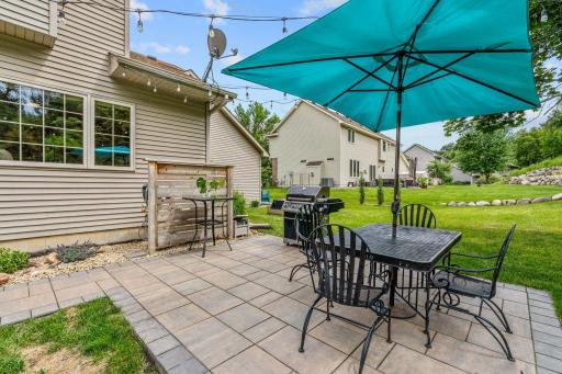 Peaceful backyard w/ oversized paver patio, mature trees, privacy + extensive landscaping